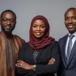 i want an image showing 3 africans one man wearing boubou, one woman with hijab and one man wearing suit. all 3 are experts and consultants standing facing to us.